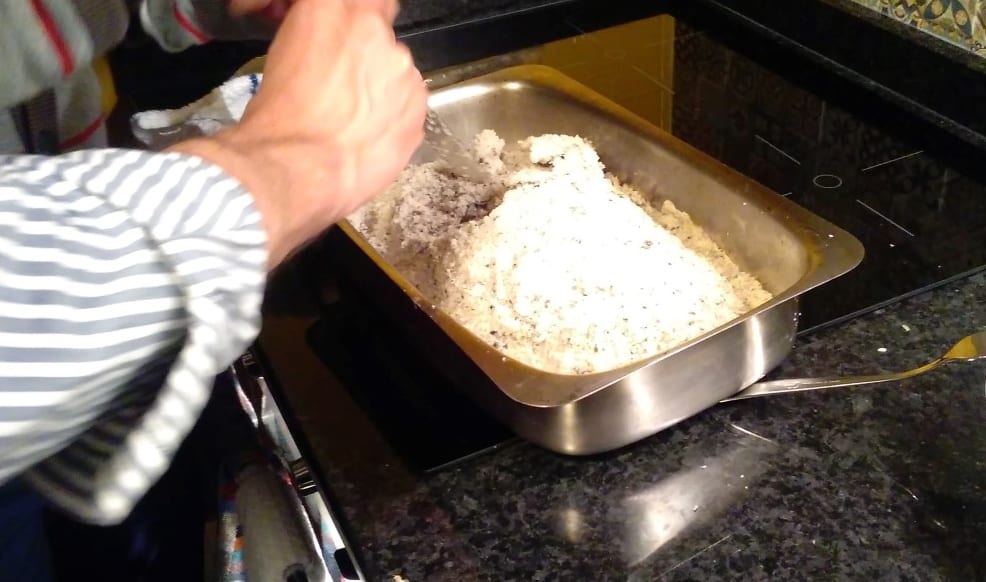Processo de partir a carapaça de sal que envolve o peixe.